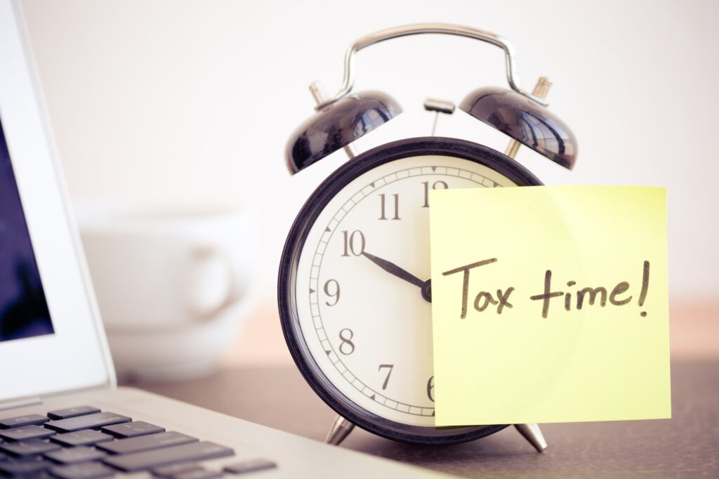 Alarm with a post it reminding about tax season